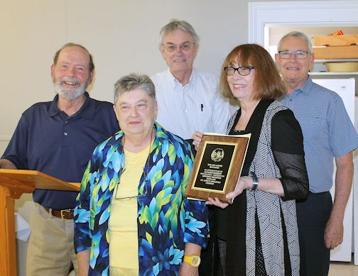 Russell Brubacher (left), joins wardens Elaine Emmerton and Ian Johnson (right), in presenting a plaque of appreciation to Tim and Jessie McGinnis who duplicated the church`s register book